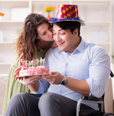 Young family celebrating birthday with disabled personの写真素材