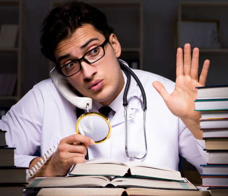 Medical student preparing for university exams at nightの写真素材