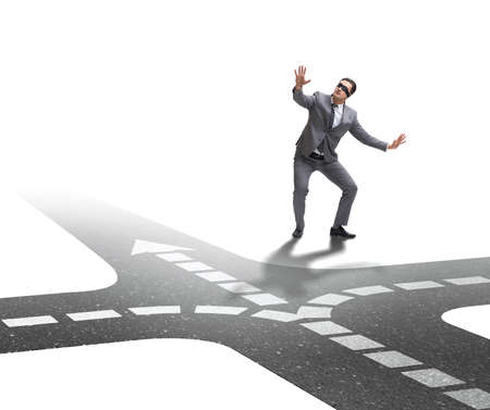 Young businessman at crossroads in uncertainty conceptの写真素材