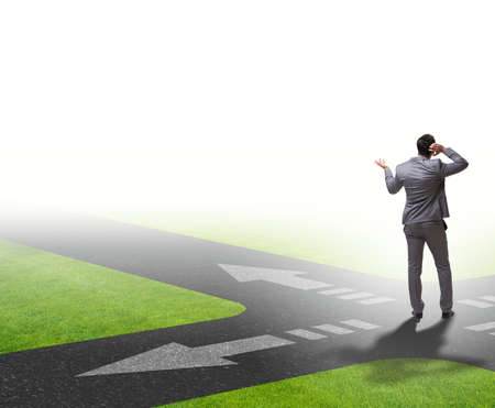 Young businessman at crossroads in uncertainty conceptの写真素材