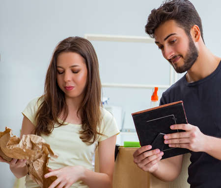 Young family unpacking at new house with boxes