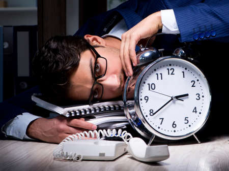 Businessman working overtime long hours late in officeの写真素材