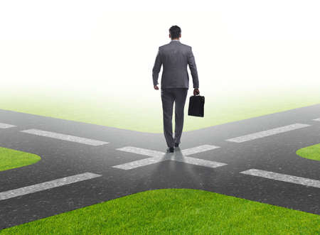Young businessman at crossroads in uncertainty concept