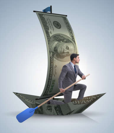 Businessman rowing on dollar boat in business financial conceptの写真素材