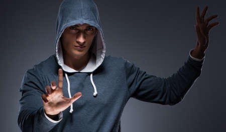 Young man wearing hoodie pressing virtual buttonsの写真素材