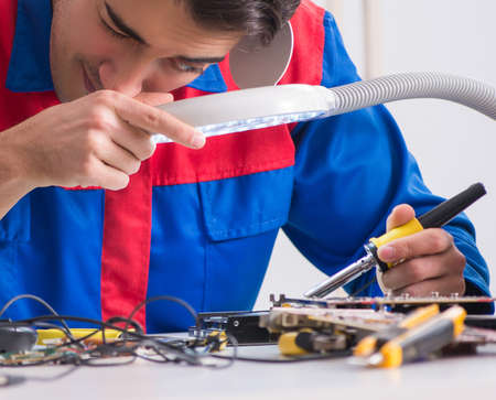 Professional repairman repairing computer in workshop