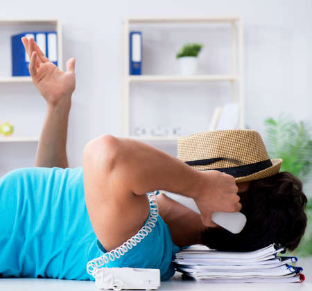 Businessman preparing for vacation in the officeの写真素材