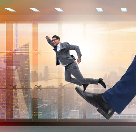 Bad angry boss kicking employee in business conceptの写真素材