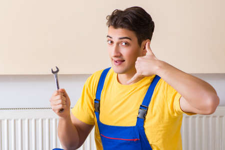 Young repairman contractor repairing heating panelの写真素材