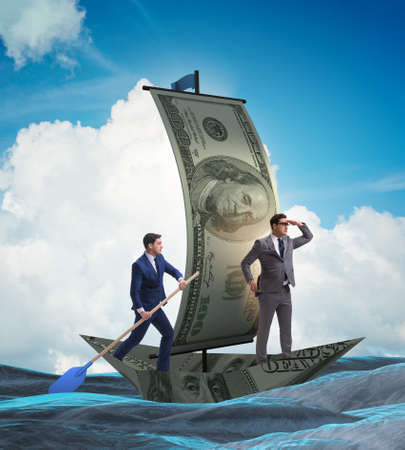 Business partnership with businessmen sailing on dollar boatの写真素材