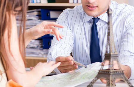 Male travel agent with customer in agencyの写真素材