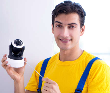 Contractor installing surveillance CCTV cameras in office