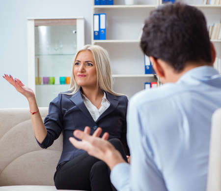 Young woman visiting psychiatrist man doctor for consultationの写真素材