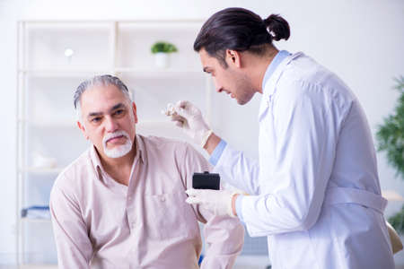 Male patient with hearing problem visiting doctor otorhinolaryngの写真素材