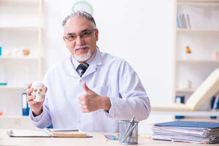 Aged male doctor with skeletonの写真素材
