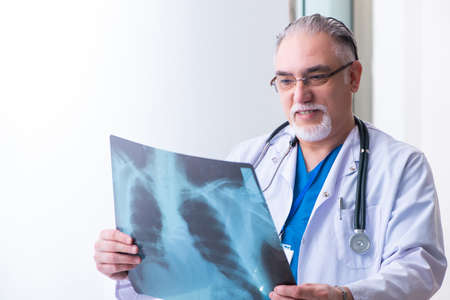 Old male doctor working in the clinicの写真素材