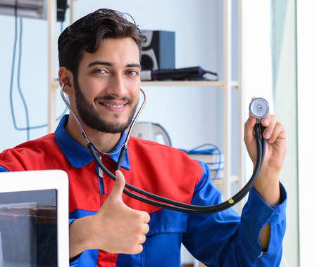 Young repairman fixing and repairing microwave oven