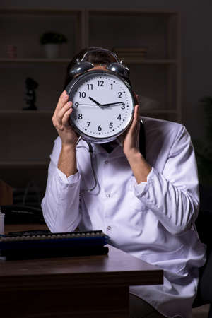 Young male doctor in the hospital at nightの写真素材