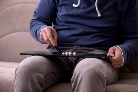 Young man having problems with narcotics at home