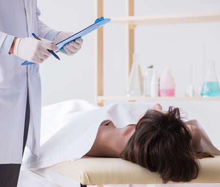 Police coroner examining dead body corpse in morgue