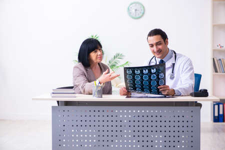 Young doctor examining senior old woman