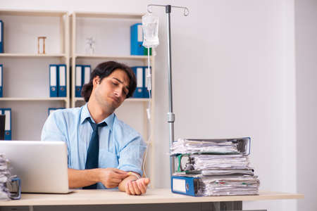 Young male employee in blood transfusion conceptの写真素材