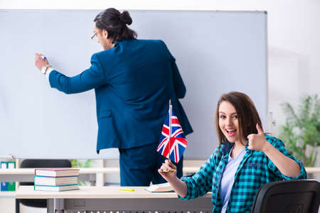 Male english teacher and female student in the classroomの写真素材
