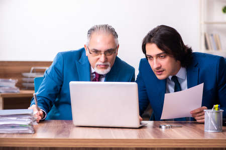 Young and old employees working together in the officeの写真素材