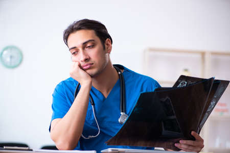 Young male doctor looking at x-ray images