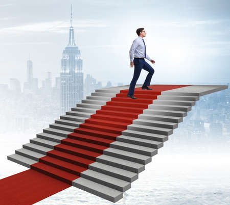 Young businessman climbing stairs and red carpet