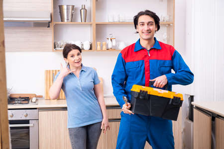 Young male repairman repairing tapの写真素材