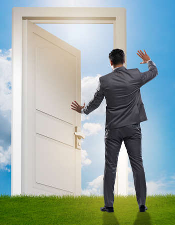 Businessman standing in front of door into futureの写真素材