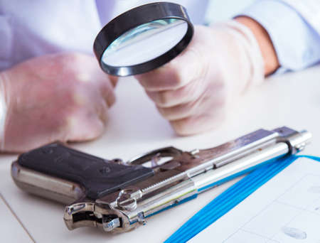 Criminologist police chemist looking at crime evidenceの写真素材