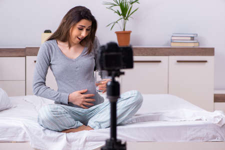Pregnant woman recording video for her blogの写真素材