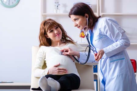 Young pregnant woman visiting experienced doctor gynecologistの写真素材