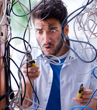 Computer repairman working on repairing network in IT workshopの写真素材