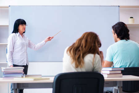 Old female english teacher and students in the classroomの写真素材