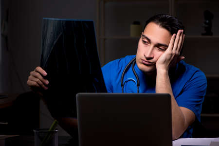 Young male doctor in the hospital at nightの写真素材