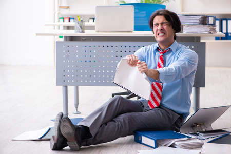 Young male employee unhappy with excessive workの写真素材