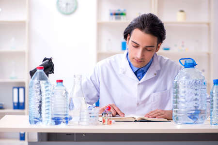 Young male chemist experimenting in labの写真素材