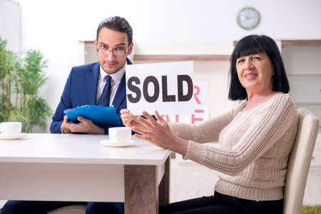 Male real estate agent and female client in the apartmentの写真素材