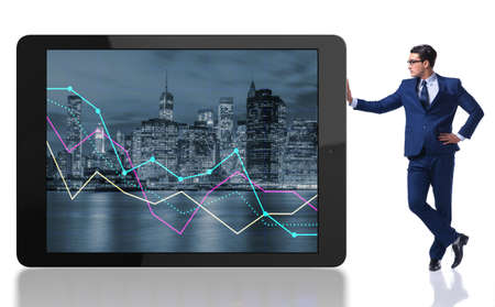 Businessman standing next to tablet computer on white backgroundの写真素材