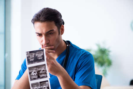 Young male doctor looking at doppler imagesの写真素材
