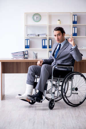 Male employee in wheel-chair in the officeの写真素材