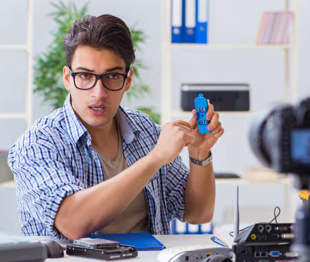 Blogger recording computer repair on camera for blogの写真素材