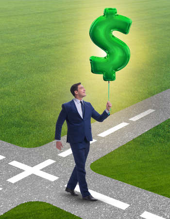 Businessman walking with inflatable dollar signの写真素材