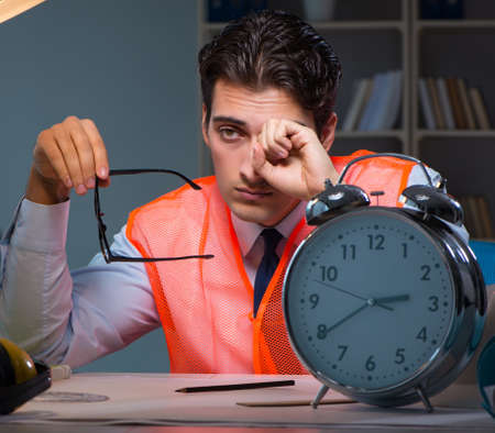 Tired architect working late long hours under stress to meet deaの写真素材