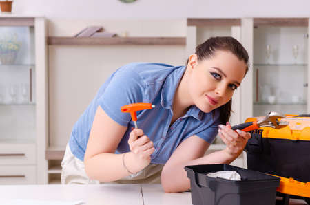Young woman repairing chair at homeの写真素材
