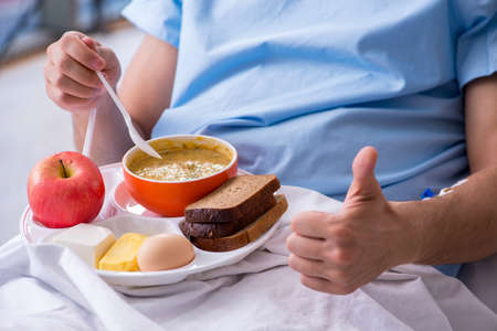 Male patient eating food in the hospitalの写真素材
