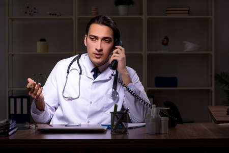Young male doctor in the hospital at nightの写真素材
